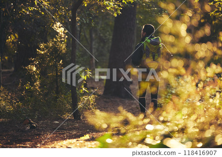 Person, backpacking and hiking in nature forest, trekking woods or trees for adventure, relax workout or fitness exercise. Behind man, walking or hiker in environment, healthcare or morning wellness 118416907