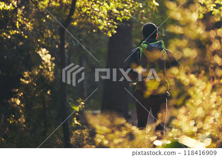 Hiker, backpacking and hiking in nature forest, trekking woods or trees for adventure, relax workout or fitness exercise. Behind man, walking or person in environment, healthcare or morning wellness 118416909
