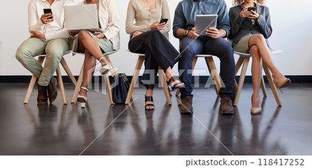 Technology, legs and people waiting for an interview in line at a human resources office as candidates for a vacancy. We are hiring, recruitment and opportunity with man and woman employees online Technology, legs and people waiting for an interview in line at a human resources office as candidates for a vacancy. We are hiring, recruitment and opportunity with man and woman employees online 118417252