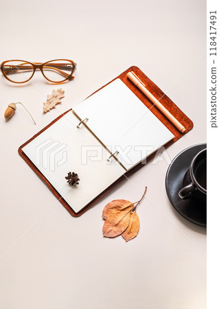 Minimalist workspace with open notebook, glasses and coffee cup. Minimalist workspace with open notebook, glasses and coffee cup. 118417491