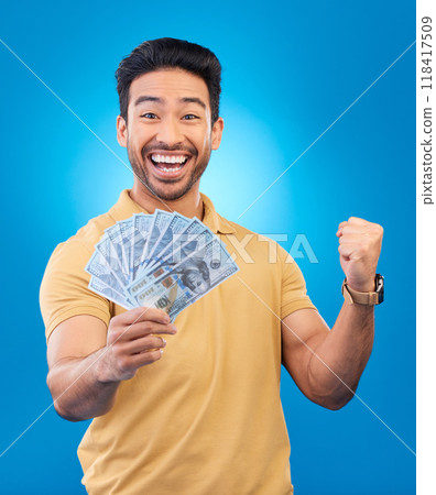 Money, fist pump portrait and man excited for dollar bills, financial achievement award or bonus salary prize. Show cash, happy winner and person cheers for income, revenue or win on blue background 118417509