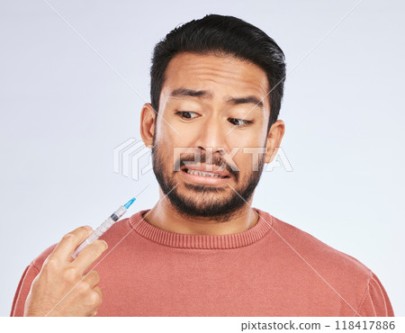 Fear, vaccine and face of asian man in studio with needle, phobia or covid scare on grey background. Corona, compliance and male person afraid of vaccination, medicine or prescription diabetic shot Fear, vaccine and face of asian man in studio with needle, phobia or covid scare on grey background. Corona, compliance and male person afraid of vaccination, medicine or prescription diabetic shot 118417886