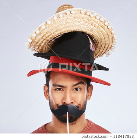 Photo booth, hat and portrait of man with mustache for comic, humor and funny joke in studio. Happy, Mexican party accessory and silly face of male person on gray background with sombrero for comedy Photo booth, hat and portrait of man with mustache for comic, humor and funny joke in studio. Happy, Mexican party accessory and silly face of male person on gray background with sombrero for comedy 118417888