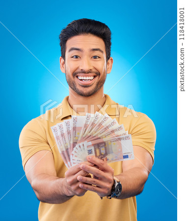 Money, portrait and young man or winner with bonus, financial success and winning, cashback prize or lottery. Happy Asian person with savings, cash and investment isolated on studio blue background Money, portrait and young man or winner with bonus, financial success and winning, cashback prize or lottery. Happy Asian person with savings, cash and investment isolated on studio blue background 118418001