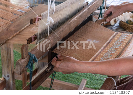 The traditional weaving of handmade cotton on the manual wood loom in Thailand. 118418207