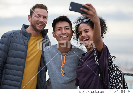 Men, black woman and friends selfie at beach for holiday travel, together and smile for internet blog post. Outdoor adventure, phone and profile picture for social media app by ocean with diversity 118418469