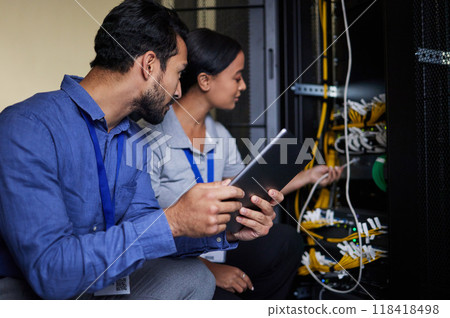 Engineer teamwork, server room and tablet for connection cable, maintenance or software update at night. Cybersecurity wire, programmers or man and woman with technology for networking in data center Engineer teamwork, server room and tablet for connection cable, maintenance or software update at night. Cybersecurity wire, programmers or man and woman with technology for networking in data center 118418498