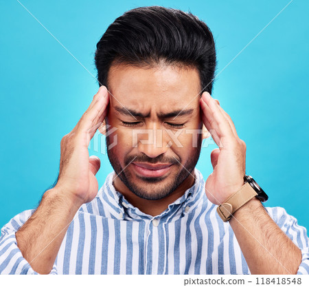 Man with headache, pain and stress with anxiety and mental health problem or crisis isolated on blue background. Male person hands holding head, massage temple with depression and migraine in studio Man with headache, pain and stress with anxiety and mental health problem or crisis isolated on blue background. Male person hands holding head, massage temple with depression and migraine in studio 118418548