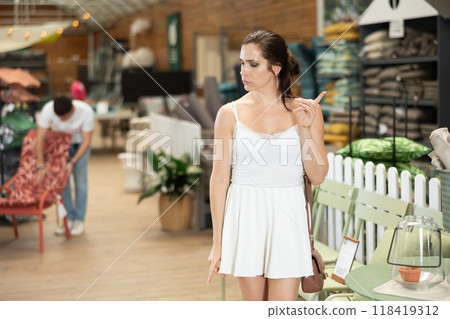 Female shopper choosing products in gardening supply store 118419312