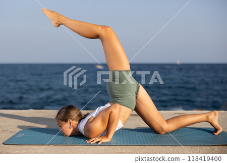 Various yoga poses performed by a sporty girl on sunny seaside Various yoga poses performed by a sporty girl on sunny seaside 118419400