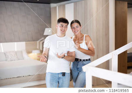 Young couple choosing convenient mattress in furniture shop 118419565