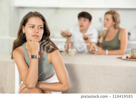 Mother-in-law and son scold young daughter-in-law in home kitchen Mother-in-law and son scold young daughter-in-law in home kitchen 118419583