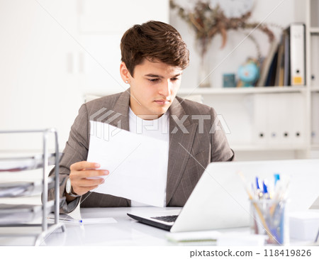 Businessman works in the office - puts documents in order and draws up contract 118419826