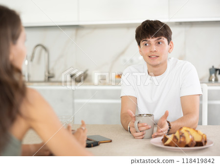 Young couple drinking tea and talking in kitchen Young couple drinking tea and talking in kitchen 118419842