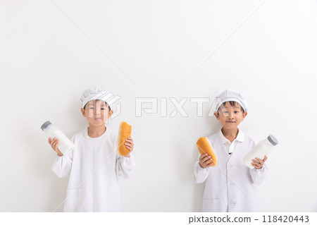A boy holding a bread roll and milk A boy holding a bread roll and milk 118420443