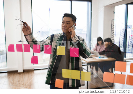 Business professional planning strategy on glass board with sticky notes 118421042