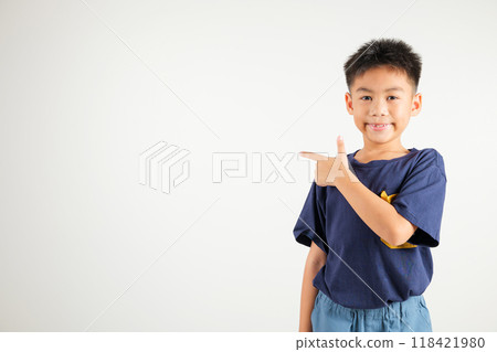 Happy Asian portrait cute young kid boy smiling indicate finger empty space, studio shot isolated on white background, Thai primary child pointing index out with copy space Happy Asian portrait cute young kid boy smiling indicate finger empty space, studio shot isolated on white background, Thai primary child pointing index out with copy space 118421980
