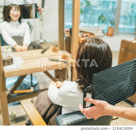 Adult woman checking the results at a beauty salon Adult woman checking the results at a beauty salon 118423084
