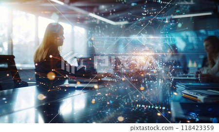 A woman is sitting at a desk with a laptop in front of her A woman is sitting at a desk with a laptop in front of her 118423359