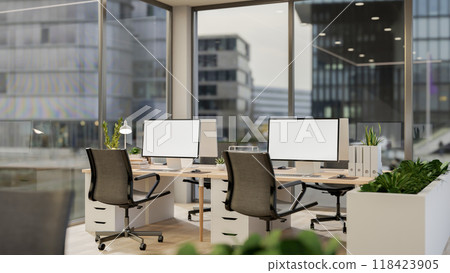 A modern office in a skyscraper features computers on desks by the window with a stunning view. 118423905