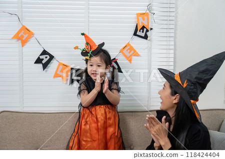 Mother and Daughter Celebrating Halloween with Costumes and Decorations at Home Mother and Daughter Celebrating Halloween with Costumes and Decorations at Home 118424404