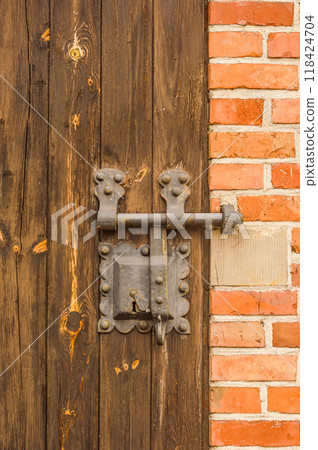 Close-up view of an ancient door key lock on an old wooden door. High quality photo 118424704