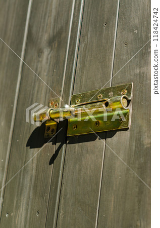 wooden door with a metal bolt lock, showcasing texture and detail in security. High quality photo wooden door with a metal bolt lock, showcasing texture and detail in security. High quality photo 118424742