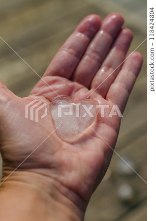 heart shaped ice cubes on women hand . High quality photo heart shaped ice cubes on women hand . High quality photo 118424804