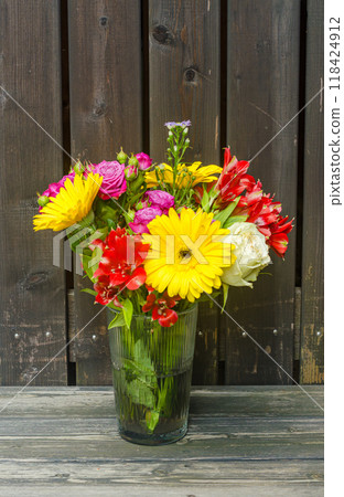bouquet of colourful flowers in glass vase on the wooden background . High quality photo bouquet of colourful flowers in glass vase on the wooden background . High quality photo 118424912