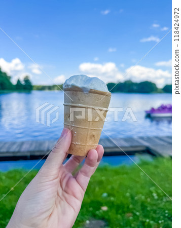 hand holds a waffle of ice cream on a background of water. High quality photo hand holds a waffle of ice cream on a background of water. High quality photo 118424972