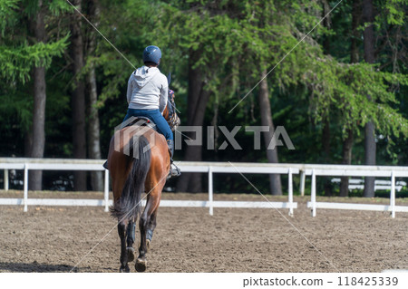 A girl practicing horse riding A girl practicing horse riding 118425339