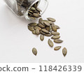 Pumpkin seeds spilled from a glass jar 118426339