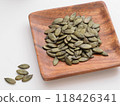 Pumpkin seeds on a wooden plate 118426341