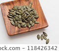 Pumpkin seeds on a wooden plate 118426342