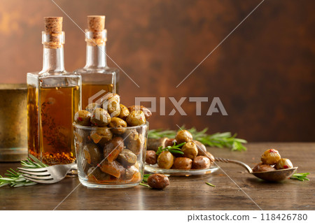 Spicy olives and bottles of olive oil on a wooden table. Spicy olives and bottles of olive oil on a wooden table. 118426780