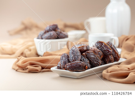 Dates in white dish on a beige background. Dates in white dish on a beige background. 118426784