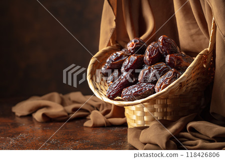 Dates in a old basket on a brown background. 118426806