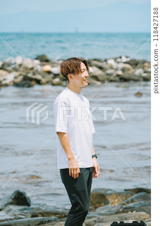 站在海灘上的年輕人 118427188