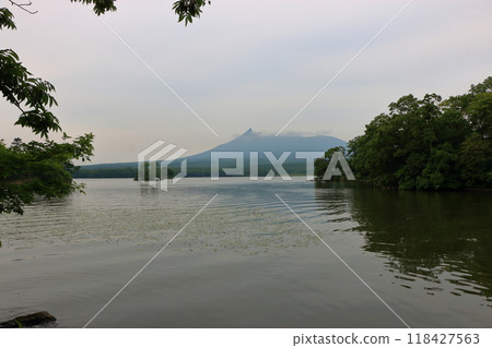 Mt. Komagatake, an active volcano between Mori town, Shikabe Town and Nanae towns on the Oshima peninsula in southwest Hokkaido as viewed from Onuma pond in the Oshima Park, near Hakodate Mt. Komagatake, an active volcano between Mori town, Shikabe Town and Nanae towns on the Oshima peninsula in southwest Hokkaido as viewed from Onuma pond in the Oshima Park, near Hakodate 118427563