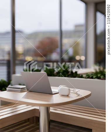 A laptop, books and headphones on a wooden table in a cozy contemporary coffee shop. 118428092