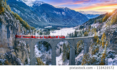 Aerial view of Train passing through famous mountain in Filisur, Switzerland. Landwasser Viaduct world heritage with train express in Swiss Alps snow winter scenery. 118428572