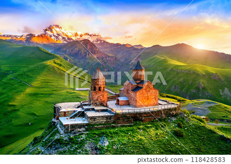 Aerial view of Gergeti trinity church at sunrise in Georgia. Aerial view of Gergeti trinity church at sunrise in Georgia. 118428583