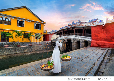Asian woman wearing vietnam culture traditional and sell the fruit on the street, Hoi an in Vietnam. Asian woman wearing vietnam culture traditional and sell the fruit on the street, Hoi an in Vietnam. 118428622