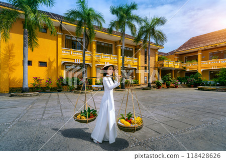 Asian woman wearing vietnam culture traditional and sell the fruit on the street, Hoi an in Vietnam. 118428626