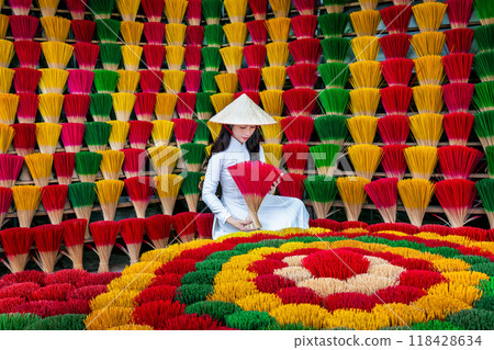 Asian woman wearing ao dai dress with Incense sticks drying in Hue, Vietnam. Asian woman wearing ao dai dress with Incense sticks drying in Hue, Vietnam. 118428634