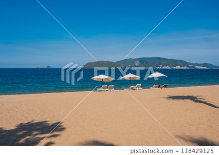 beach umbrellas with sun loungers without people on a sandy beach against the background of the sea beach umbrellas with sun loungers without people on a sandy beach against the background of the sea 118429125