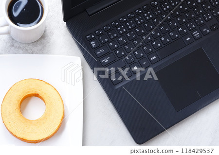 Working on a laptop while snacking on a German cake, Baumkuchen, and freshly brewed coffee Working on a laptop while snacking on a German cake, Baumkuchen, and freshly brewed coffee 118429537