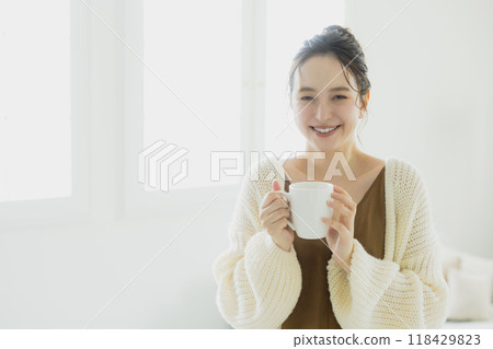 A woman drinking hot drinks A woman drinking hot drinks 118429823