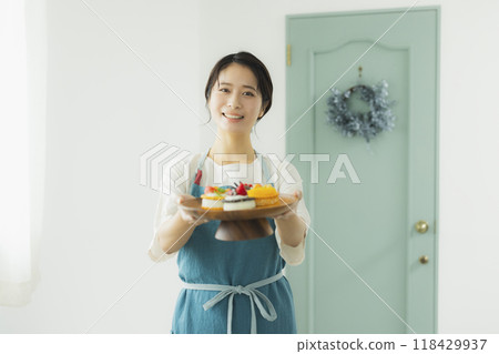 一個穿著圍裙的女人拿著糖果 118429937