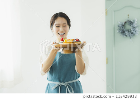 Woman in an apron holding sweets Woman in an apron holding sweets 118429938